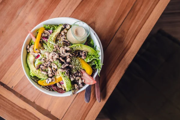 Ahşap bir masa susam remake ile ek yükü yeşil poke kase salata. Vejetaryen çiğ yemek kavramı