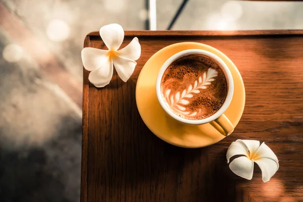Kawa Latte Art Specialty Żółtej Filiżance Kwiatami Góry Drewnianym Stole — Zdjęcie stockowe