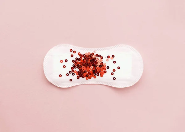 Pastel renkli arka plan üzerinde kırmızı glitter adet paneliyle. Minimalist natürmort fotoğraf kavramı
