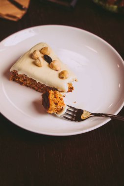 Yukarıdan kaju krem katmanda ahşap masa ile çiğ vegan havuç kek. Düşük anahtar gıda fotoğraf tasarım konsepti. 