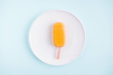 Bir çiğ vegan mango dondurma yukarıdan. Pastel mavi arka plan. Minimalizm gıda Fotoğrafçılık. Geometrik tarzı. Boşaltmak