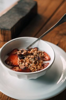 Granola yoğurtlu, çilek ahşap sehpa üzerinde. Hipster kahve dükkanı. Gıda fotoğrafçılığı kavramı. Kopya alanı