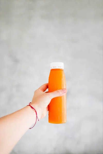 Woman Hand Holds Bottle Cold Pressed Orange Juice Gray Wall Stock Photo