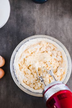 Kek ve Krep için bir kase içinde pişirme malzemeyi karıştırma. Minimalizm karanlık gıda fotoğraf tasarım konsepti. Dikey, portre