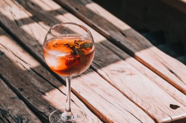 Aperol Spritz restoranda ahşap masa üzerinde şarap cam. Gıda Fotoğrafçılık. Doğrudan güneş ışığı, boşaltmak