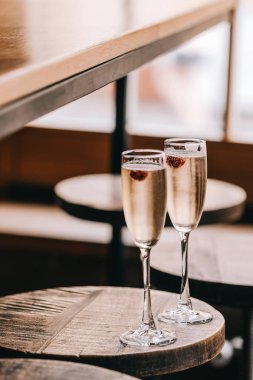 Champaigns, İtalyan köpüklü beyaz şarap pencere ışıklar karşı ahşap masa üzerinde iki kadeh. Yiyecek ve içecek photpgraphy, boşaltmak, Minimalizm