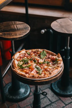 Restorandaki ahşap masada pizza carbonara. Yemek fotoğrafçılığı konsepti. Kopyalama alanı