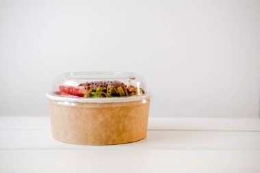Salata tek kullanımlık craft kağıt kase beyaz zemin üzerine götürün. Minimalizm gıda fotoğrafçılığı kavramı. Mockup, boşaltmak