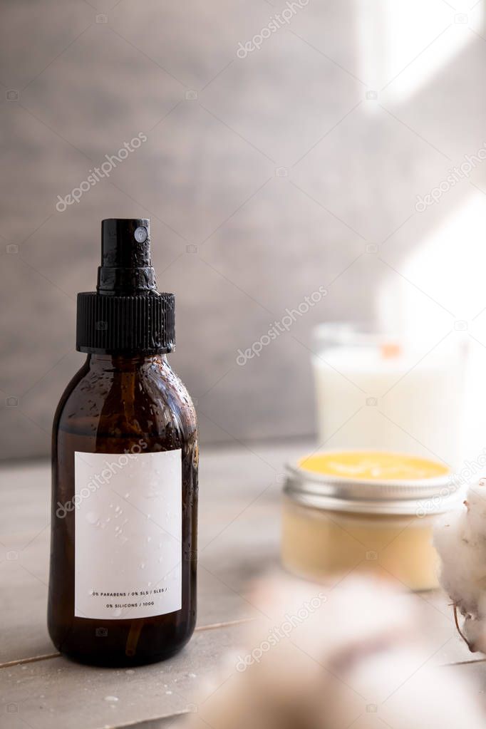 Spa cosmetics in brown glass bottles with white label on gray concrete table. Copy space for text. Beauty blogger, salon therapy, branding mockup, minimalism concept
