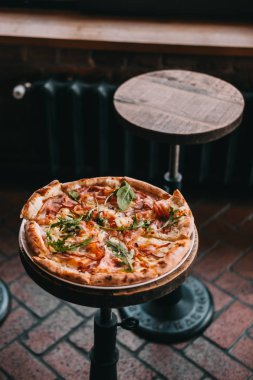 Restorandaki ahşap masada pizza carbonara. Yemek fotoğrafçılığı konsepti. Kopyalama alanı