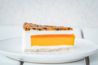 Mango, Hindistan cevizi, tutku meyve pasta Beyaz ahşap masa üzerinde parçası. Minimalizm tatlı gıda fotoğrafçılığı kavramı, boşaltmak