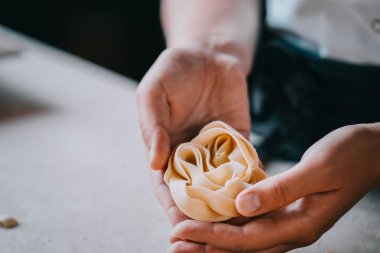 Şef kadının elleri tagliatelle makarna yapma. Pişirme işlemi. Çiğ gıda fotoğrafçılığı kavramı.