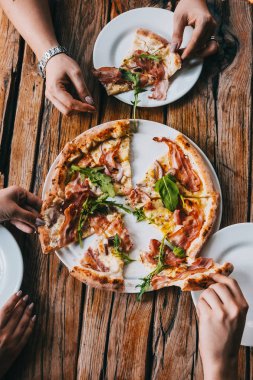 Pizza carbonara üzerinde rustik ahşap masa kapma eller. Gıda fotoğrafçılığı kavramı. Üstten görünüm