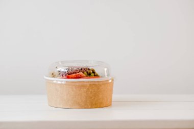 Salata tek kullanımlık craft kağıt kase beyaz zemin üzerine götürün. Minimalizm gıda fotoğrafçılığı kavramı. Mockup, boşaltmak