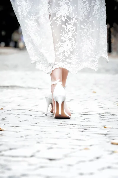 Bride in elegant high heels sandals and lace vintage dress. Closeup, copy space