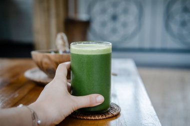 Tahta masada bir bardak yeşil kereviz suyu.