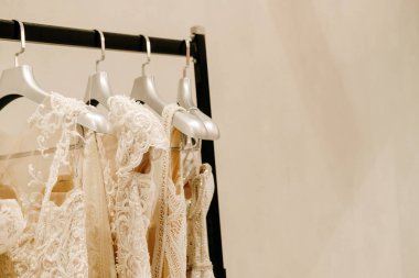 Askıda asılı krem rengi gelinlikler