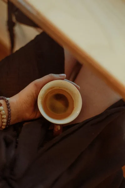 Женская рука с кофе эспрессо на ногах — стоковое фото