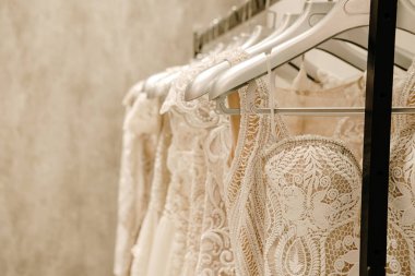 Askıda asılı krem rengi gelinlikler