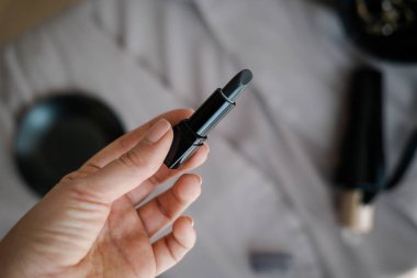 Kadın elinde siyah ruj merhem 