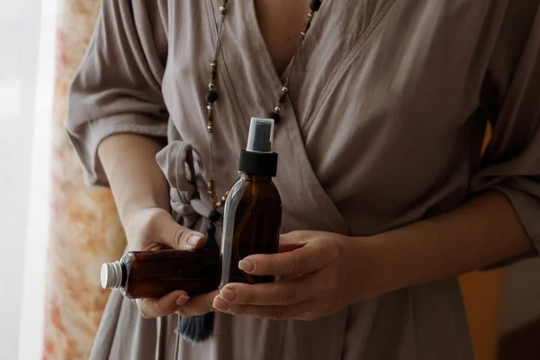 Dos botellas cosméticas en las manos de la mujer — Foto de Stock