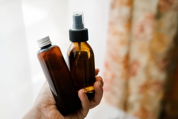 Dos botellas cosméticas en las manos de la mujer — Foto de Stock