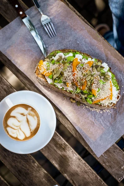 Kopi dengan roti alpukat di atas meja kayu — Stok Foto
