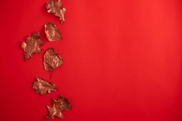 Rosa de ouro folhas de queda no fundo vermelho — Fotografia de Stock