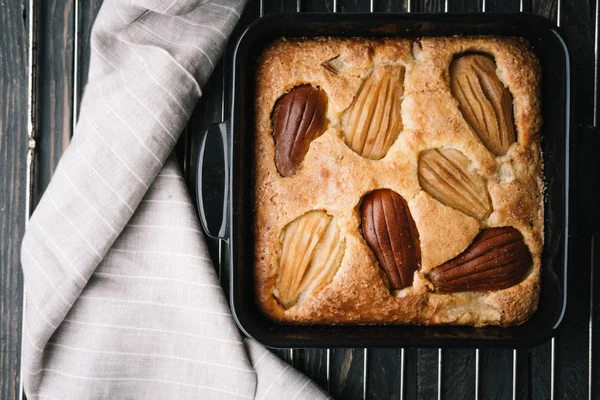 Fall french pear cake in a black ceramic bakeware — Stock Photo, Image