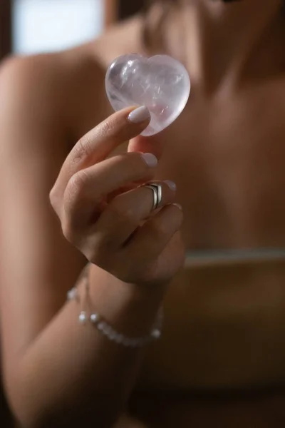 Woman holds rose quartz heart crystal — Stock Photo, Image