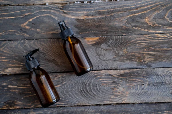 Botellas cosméticas marrones sobre mesa de madera plana — Foto de Stock