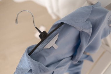 Açık mavi kumaşta kıyafet etiketi. Moda markası. Moda markası. Moda markası.