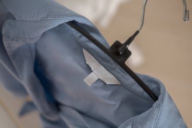 Açık mavi kumaşta kıyafet etiketi. Moda markası. Moda markası. Moda markası.