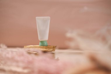 Açık pembe arka planda beyaz kozmetik tüp. Doğal minimalizm, temiz konsept. Minimum tasarım, natürmort. Güzellik blogu, cilt bakımı