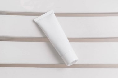 Beyaz arka planda beyaz kozmetik tüp, güzellik ürünü, marka paketi modeli, beyaz üstüne beyaz. Üst görünüm, alanı kopyala