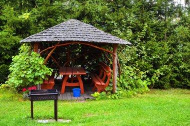 Sonbahar bahçe ahşap pergola. Tablo, banklar ve köknar ağaçları ve yeşil çim zemin karşı bahçede barbekü ile dinlenme yeri.