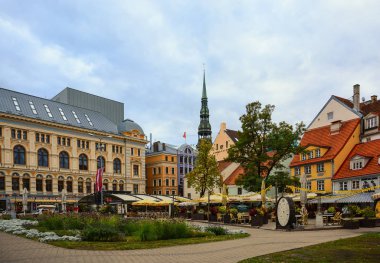 Meydanı eski binalar, kafe ve Ortaçağ Katedrali ile old Riga merkezinde St. Peter Kilisesi.
