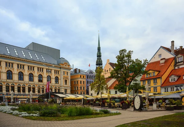 Meydanı eski binalar, kafe ve Ortaçağ Katedrali ile old Riga merkezinde St. Peter Kilisesi.
