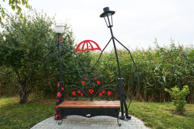 Street lamp and garden bench for lovers. Installation on the theme of love, weddings in the park of lovers of hearts, Dobroslav, Ukraine. clipart