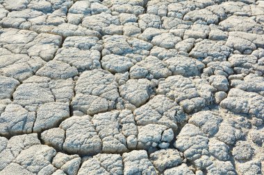 Derin çatlakları olan kuru toprak. Çamur yüzeyi çatlamış. Yerdeki çatlakların dokusu.