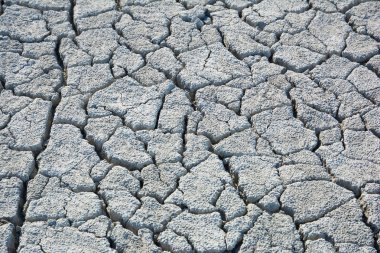 Derin çatlakları olan kuru toprak. Çamur yüzeyi çatlamış. Yerdeki çatlakların dokusu.