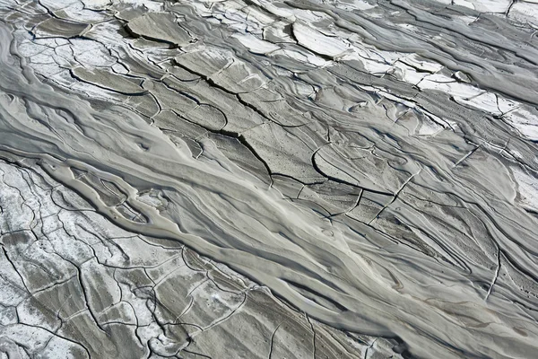 Schlammfluss aus einem Schlammvulkan. Rissige Schlammoberfläche. Mudflow Textur mit Rissen. — Stockfoto