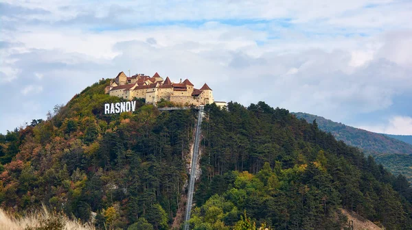 Romanya 'nın tepedeki ortaçağ duvarlı Rasnov kenti. Ortaçağ Kalesi Rasnov ile sonbahar manzarası.