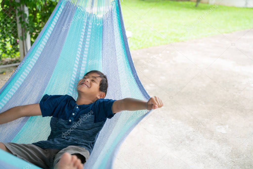 The little boy sitting at the hammock and he so happy