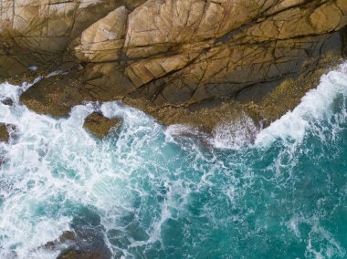 Yukarıdan görünen kayalıklara vuran deniz dalgaları.