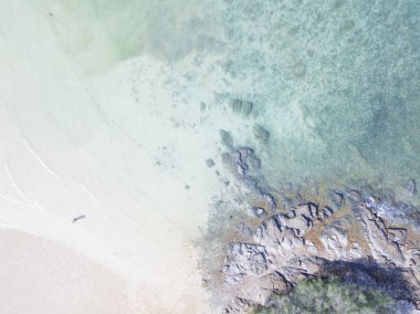 Yukarıdan görünen kayalıklara vuran deniz dalgaları.