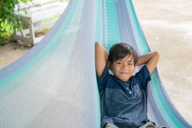 Hamakta oturan küçük çocuk çok mutluydu.