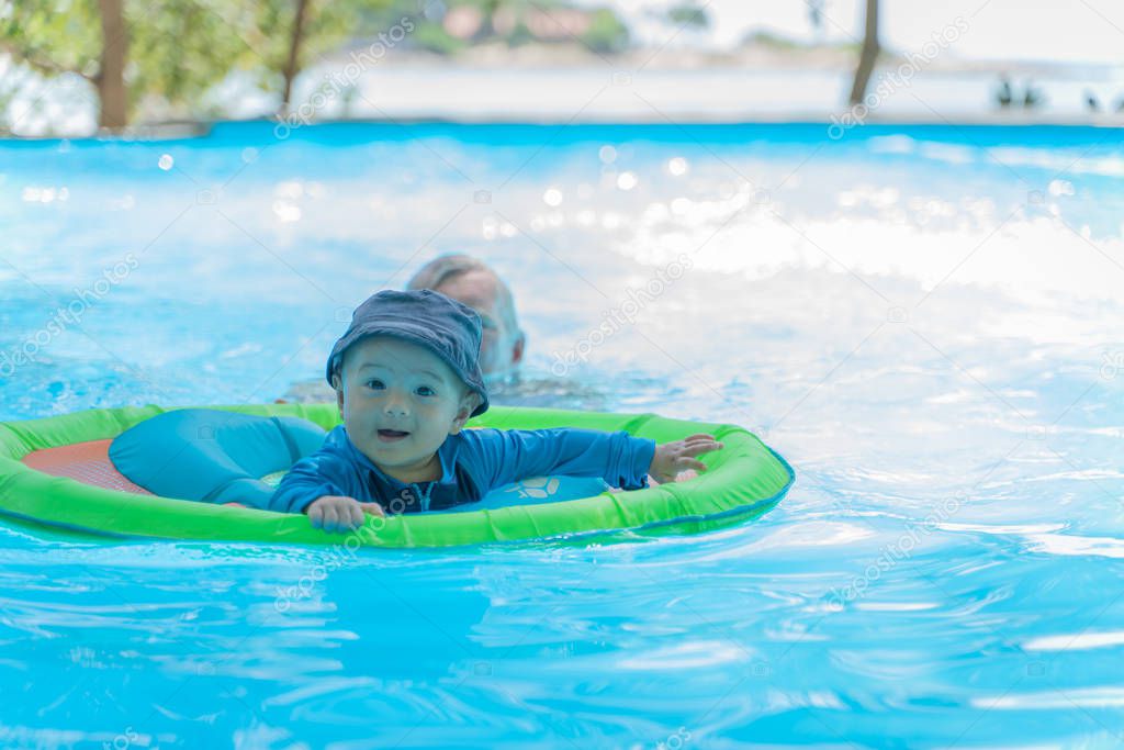 little boy swimming in the pool with blue water
