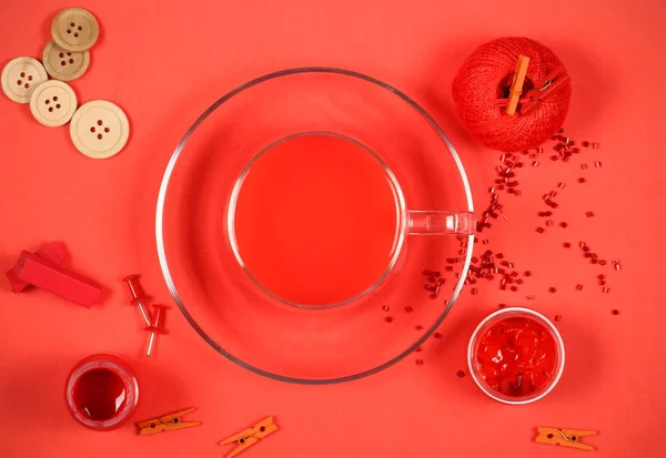 red objects for needlework lie on a red background