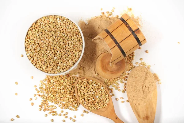 Green buckwheat and buckwheat flour lie on a white background